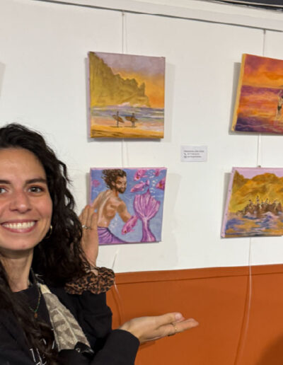 L'artiste devant 4 de ses tableaux exposés